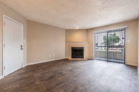 A room with a fireplace and sliding glass doors.