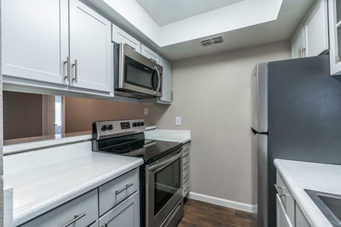 A kitchen with white cabinets and stainless steel appliances.