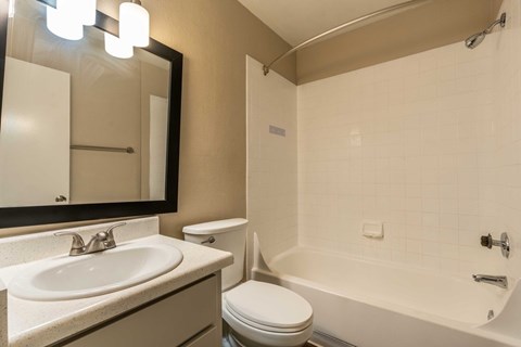 A bathroom with a white toilet, sink, and bathtub.