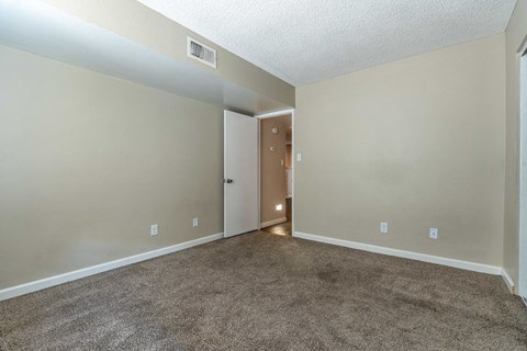 A room with a carpeted floor and a door in the middle.
