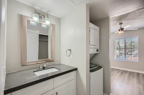 A bathroom with a sink, mirror, and a window.