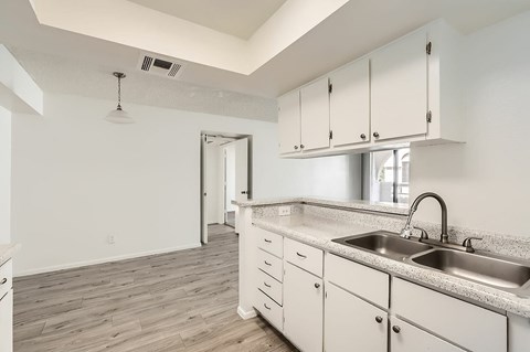 A kitchen with white cabinets and a sink.