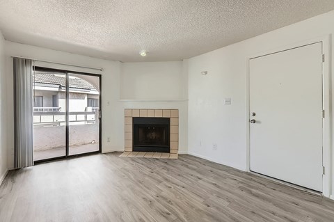 A room with a fireplace and sliding glass doors.