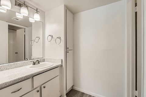 A bathroom with a sink, mirror, and light fixture.