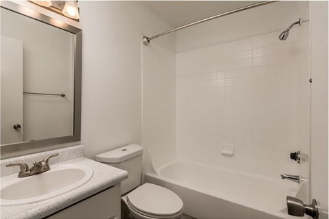 A white bathroom with a toilet, sink, and bathtub.