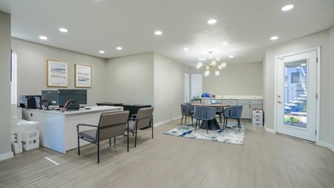 A spacious office room with a desk, chairs, and a window.