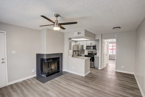 A living room with a fireplace and a ceiling fan.