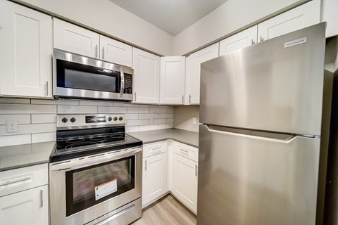 A modern kitchen with stainless steel appliances and white cabinets.