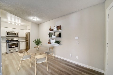 A kitchen with a dining table and chairs.
