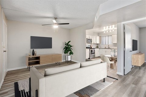 A modern living room with a white couch and a television on the wall.