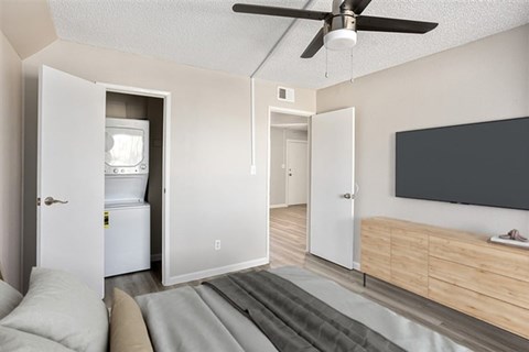 A modern living room with a television, a couch, and a refrigerator.