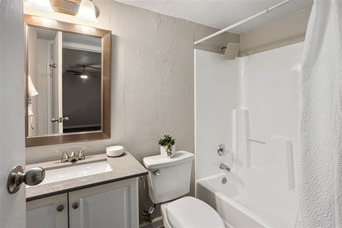 A white bathroom with a toilet, sink, and bathtub.