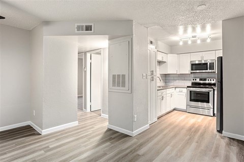 A kitchen with white cabinets and a stove top oven.