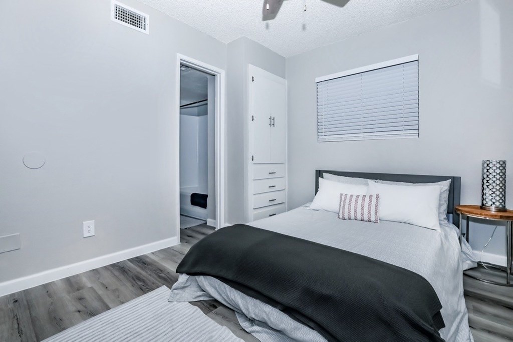 A bedroom with a bed, nightstand, and a closet.