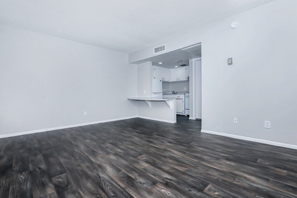 A room with wooden flooring and a white wall.