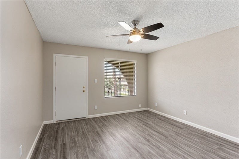 A room with a ceiling fan and a door.