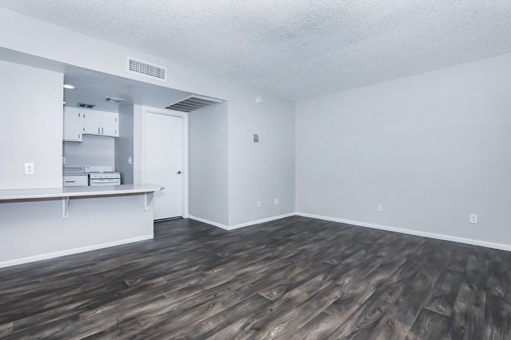 A room with wooden flooring and white walls.