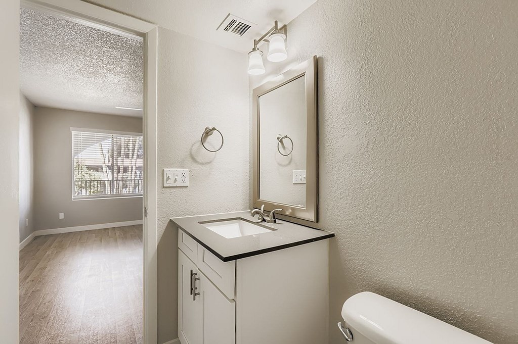 A small white room with a carpeted floor and two shelves.