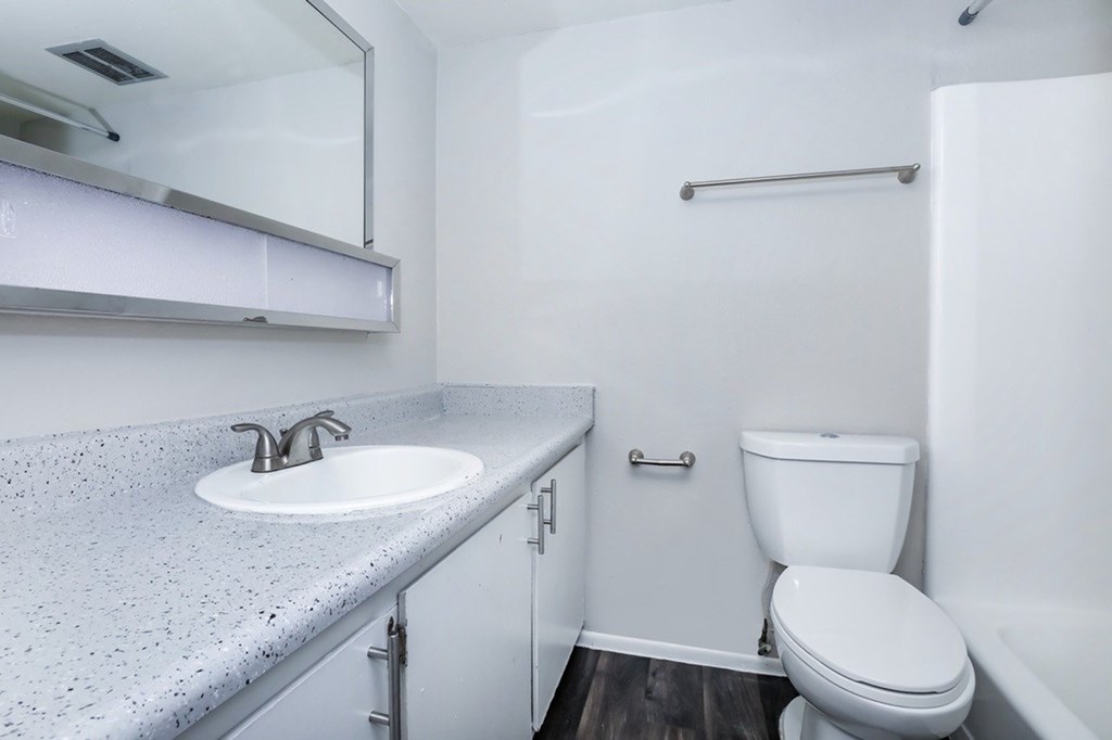 A white toilet sits next to a sink in a small bathroom.