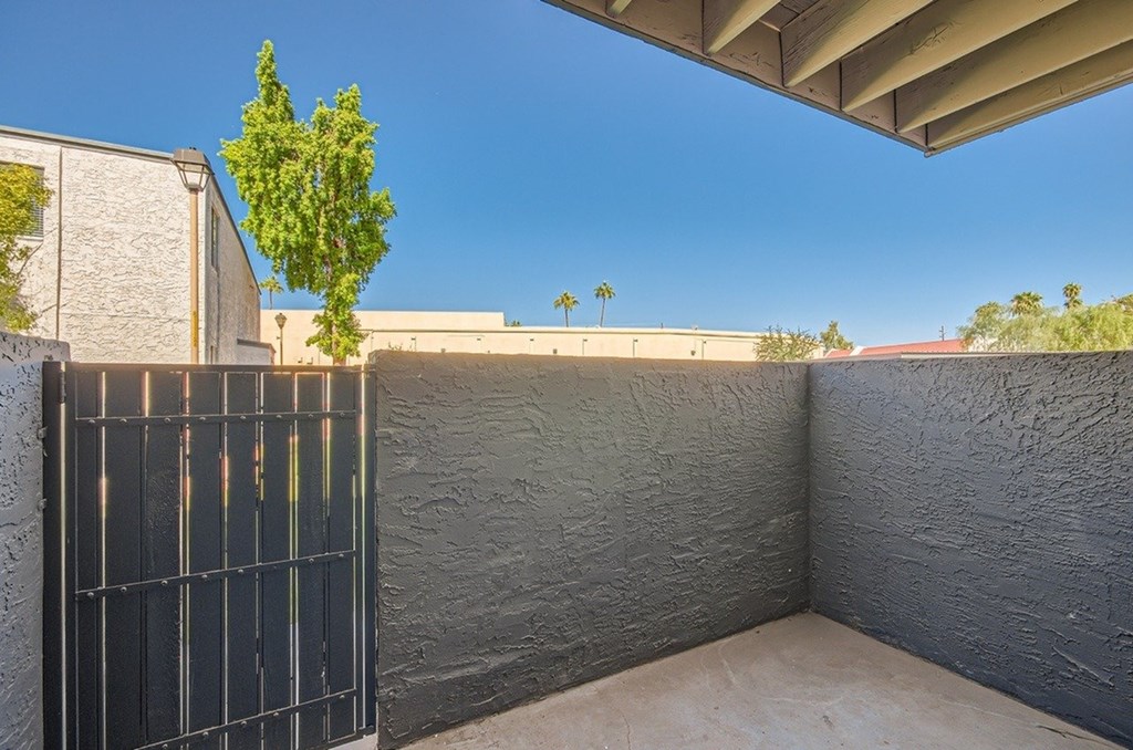 A tree is growing out of a fence.