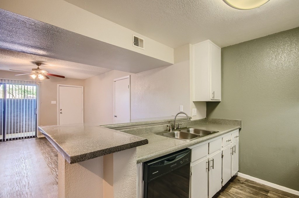 A kitchen with a stove top oven and a sink.