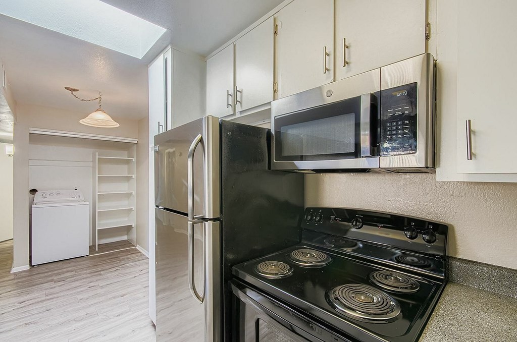 A kitchen with a white counter top and a ceiling fan.