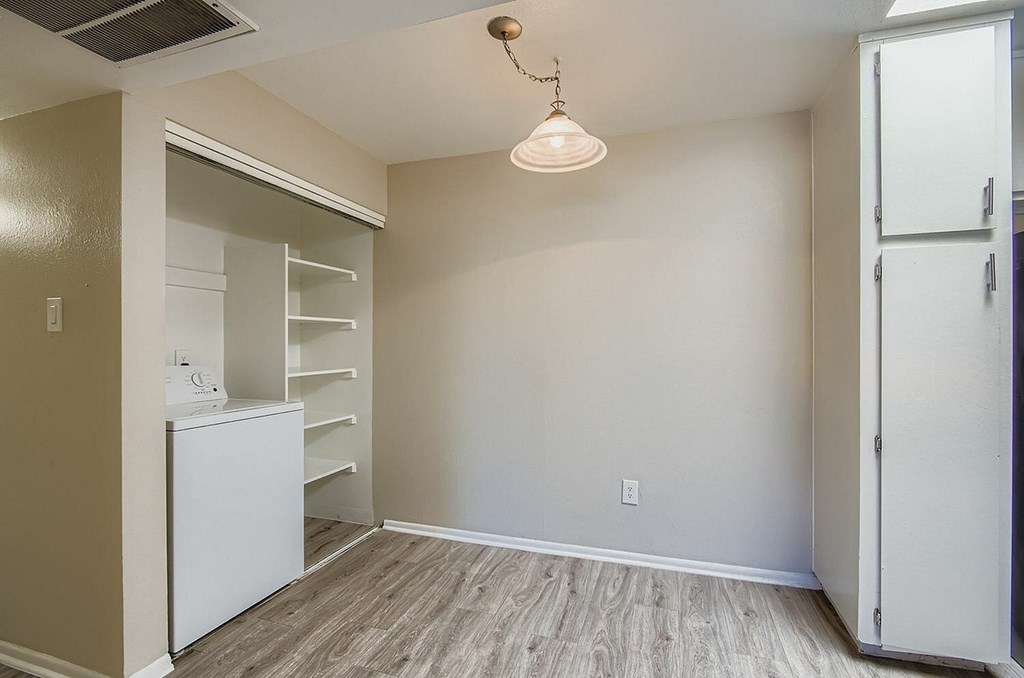 A kitchen with a refrigerator, oven, and cabinets.