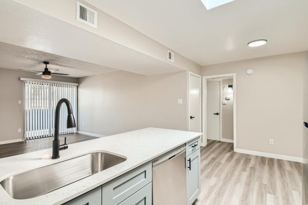 A kitchen with a sink and a fan.