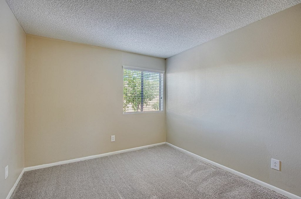 A bathroom with a toilet, sink, mirror, and light fixture.