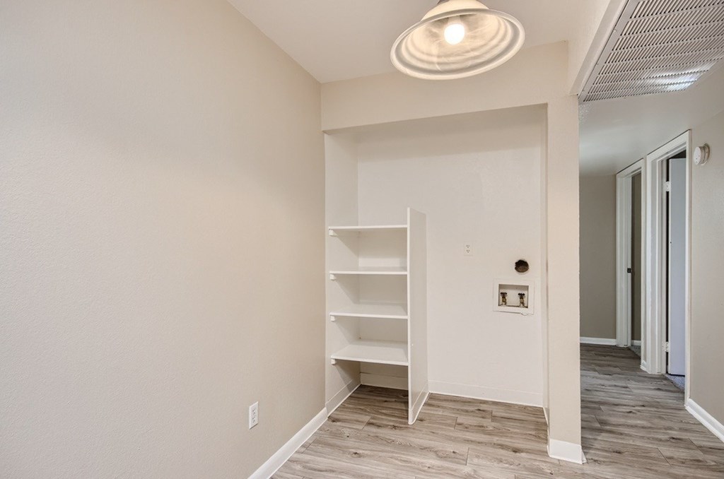 A room with a white ceiling light and a white shelving unit.