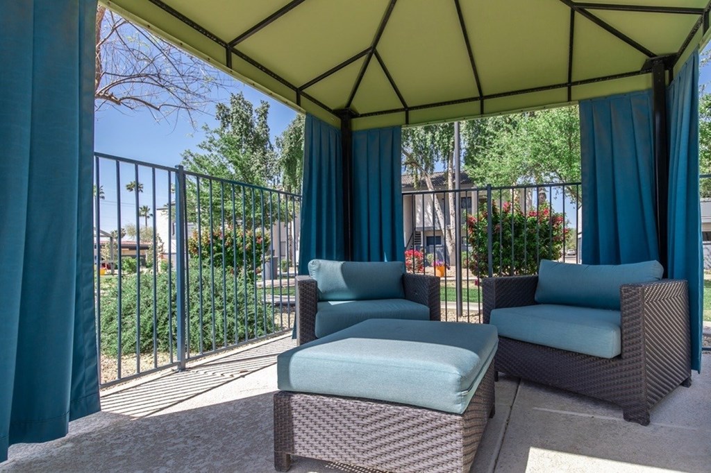 A patio with a canopy and two chairs.