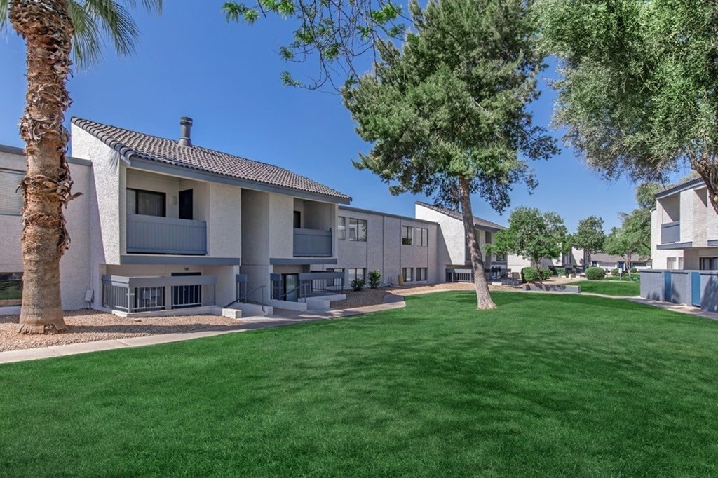 A row of houses with a green lawn in front.