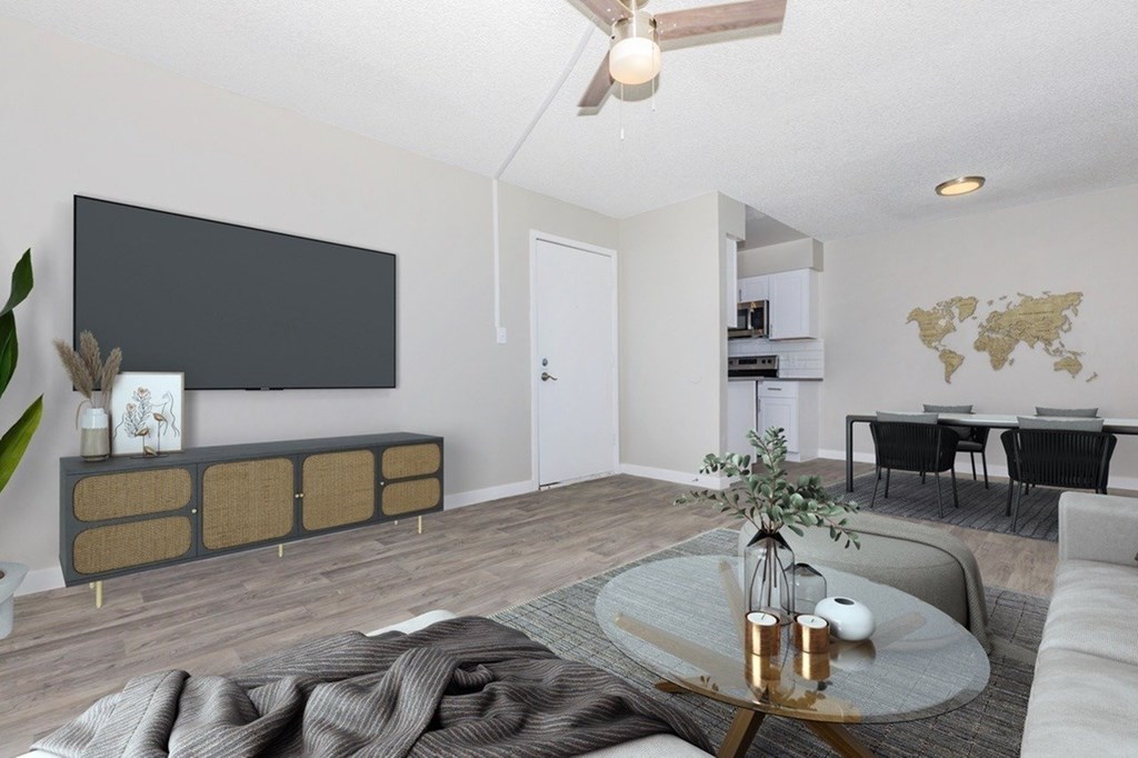 A living room with a grey sofa, a coffee table, and a world map on the wall.