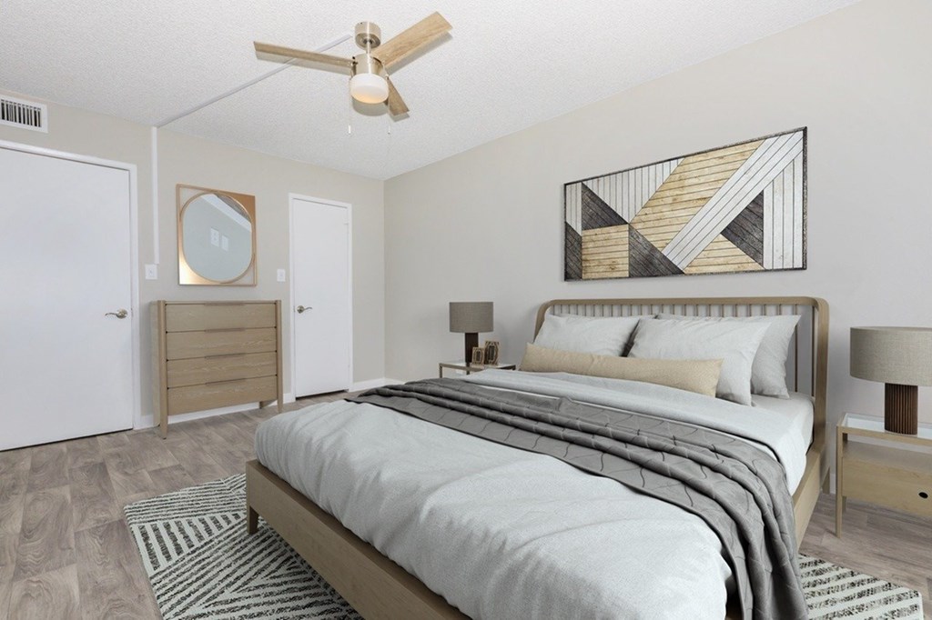 A bedroom with a bed, nightstand, and a ceiling fan.