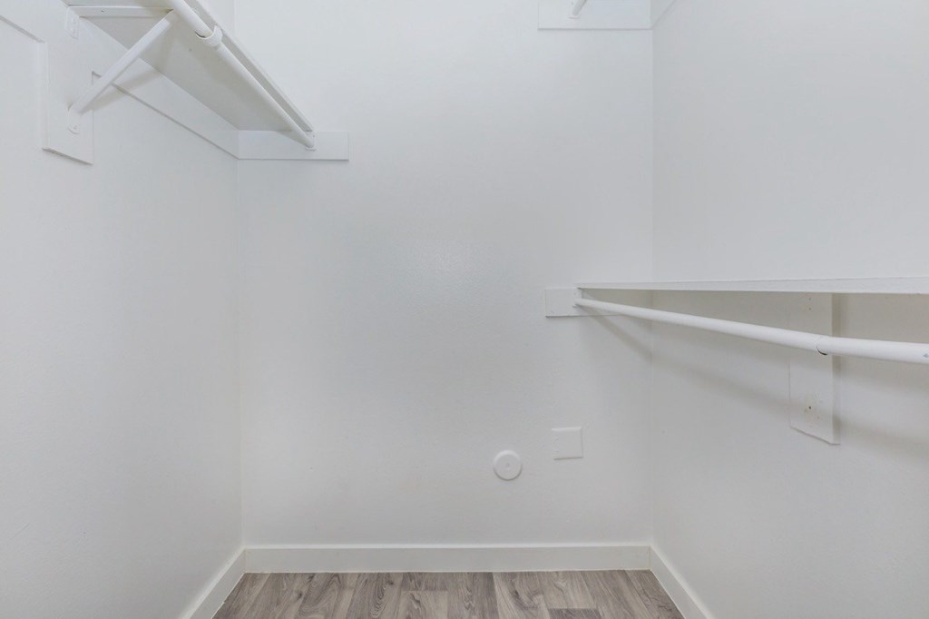 A white wall with a shelf and a light switch.