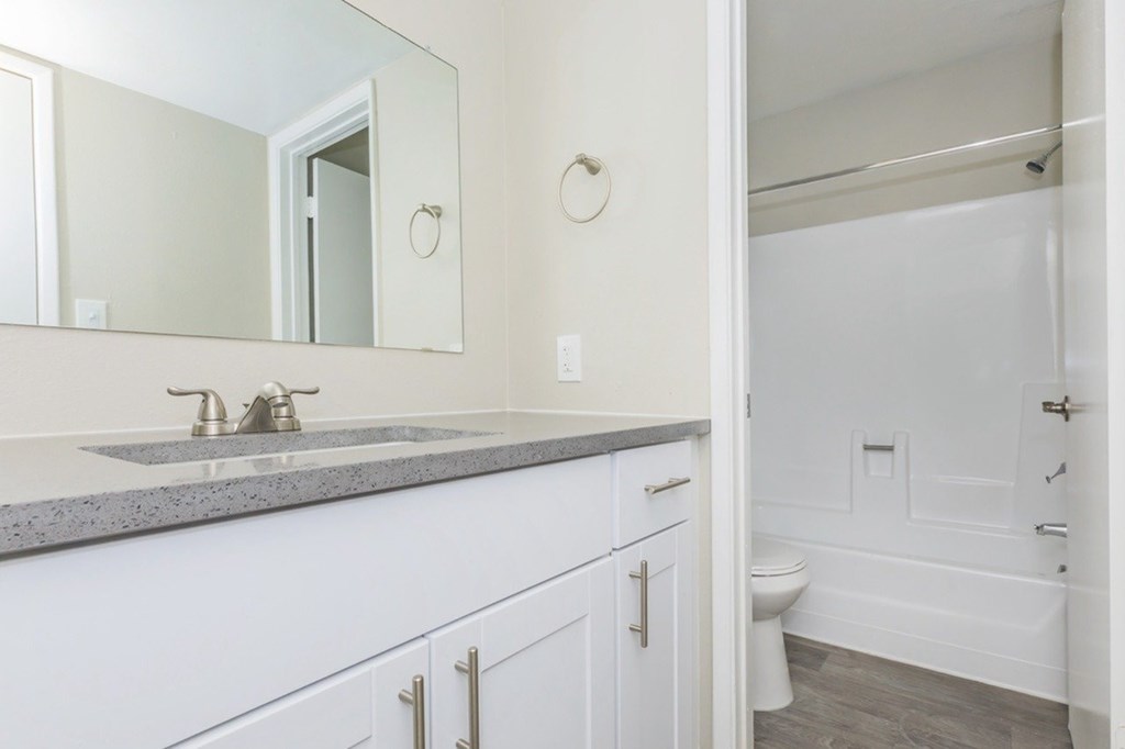 A bathroom with a white sink and a white toilet.