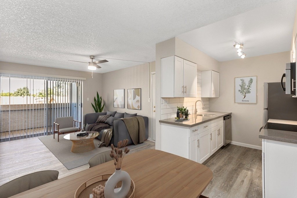 A modern kitchen with a dining table and a living area with a couch.
