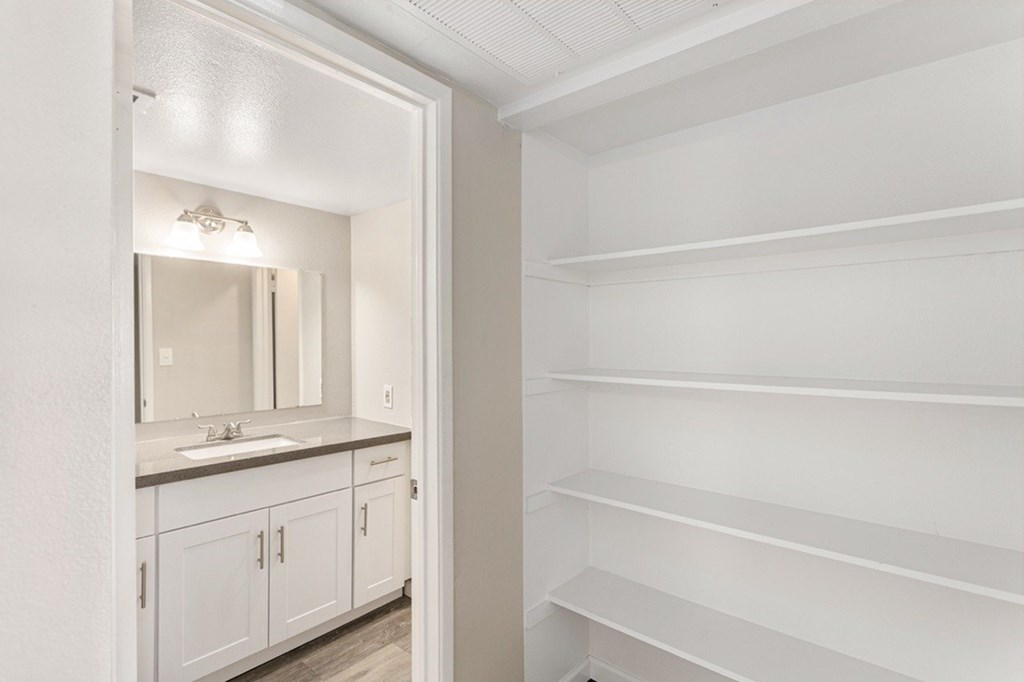 A white bathroom with a sink and mirror.