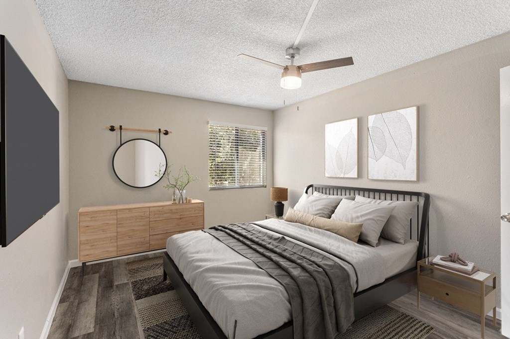 A bedroom with a bed, nightstand, and a mirror on the wall.