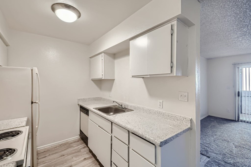 A kitchen with white cabinets and a granite countertop.