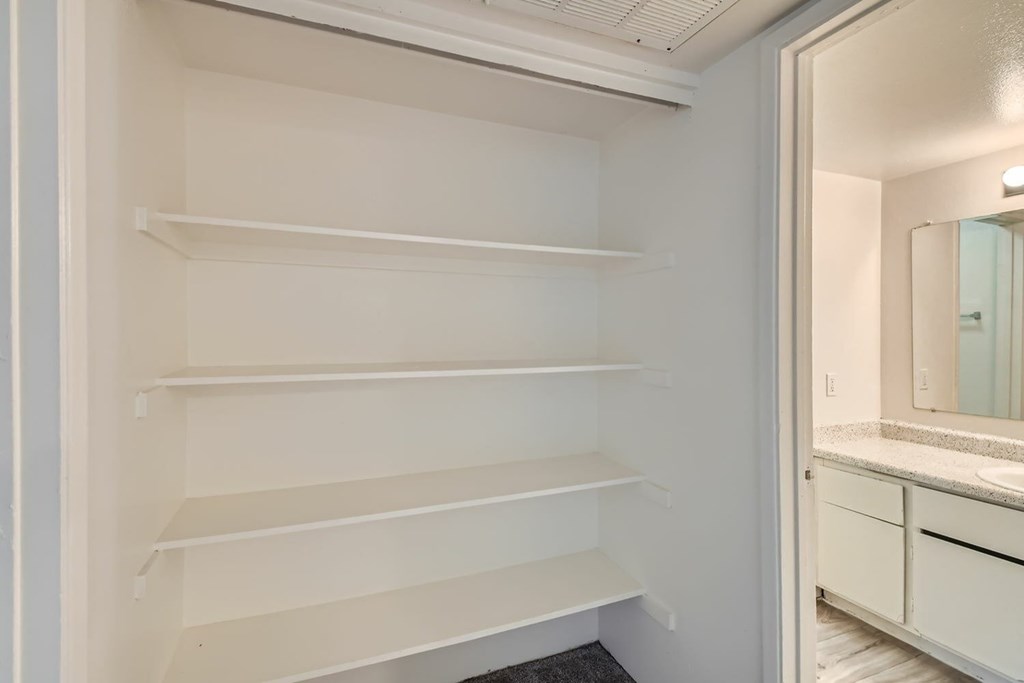 Empty white shelves in a pantry.