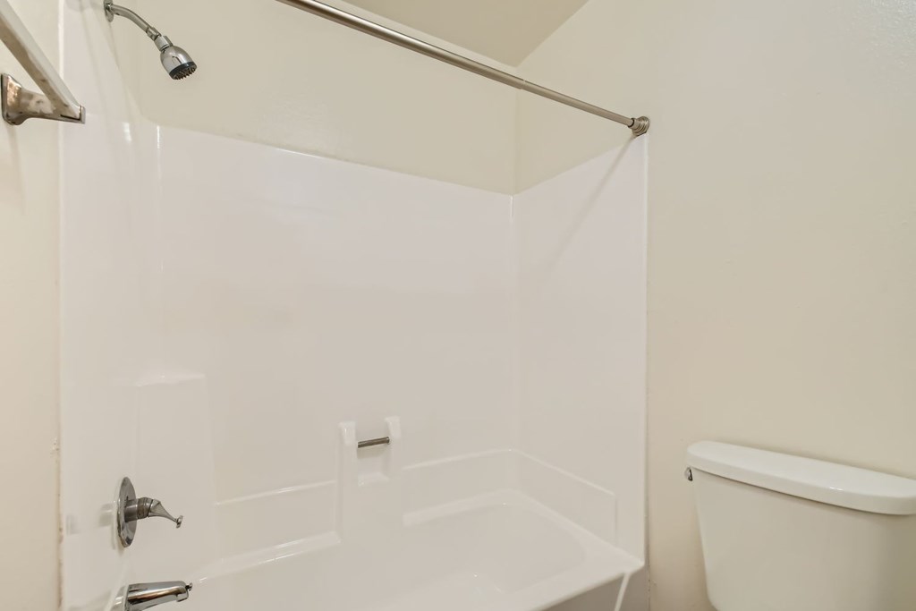 A white bathroom with a shower curtain and a bathtub.