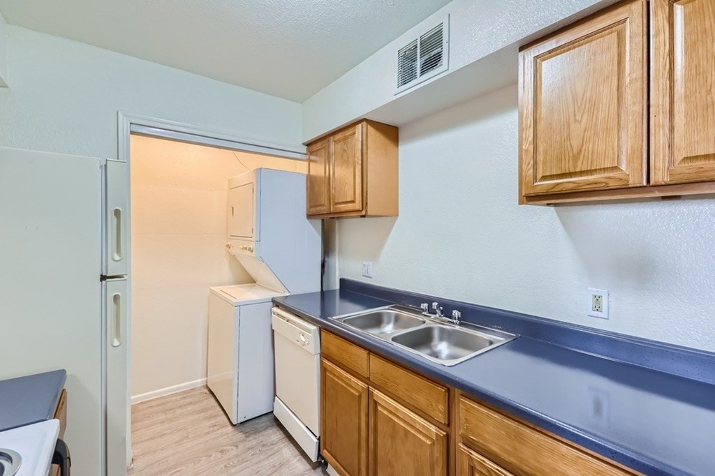 A kitchen with wooden cabinets and a white refrigerator.