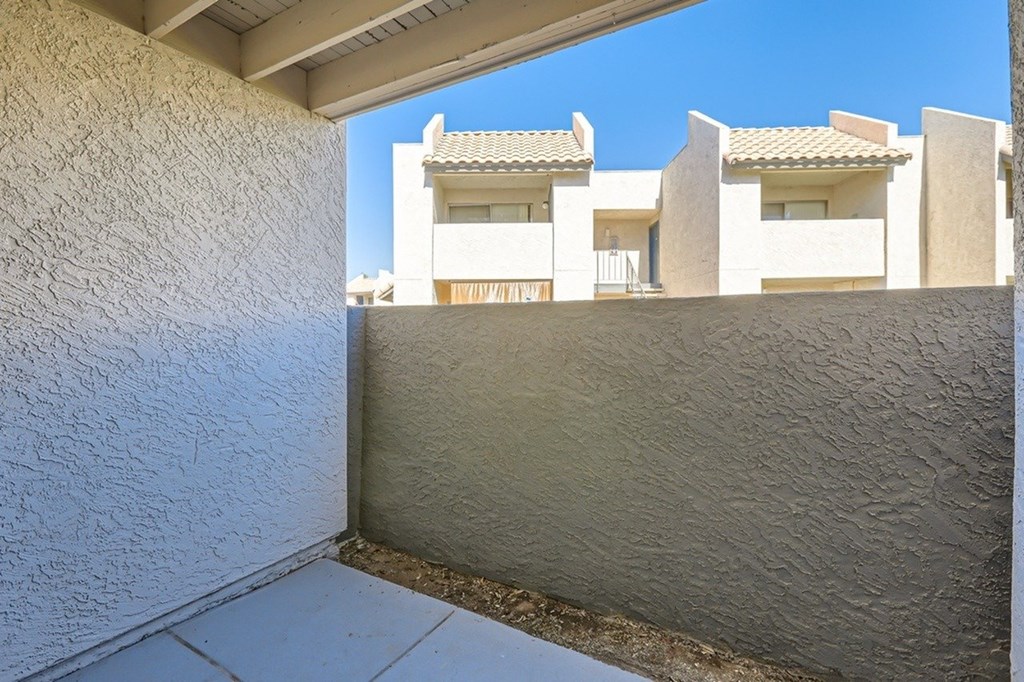 A white building with a balcony and a clear blue sky.