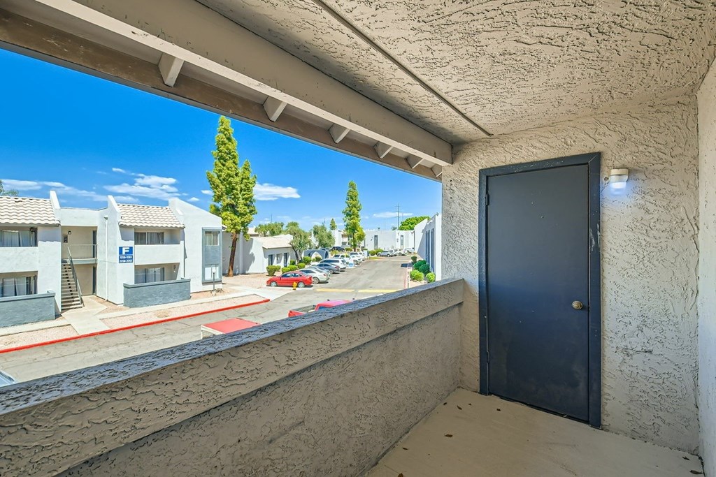 A black door is on the right side of a concrete wall.