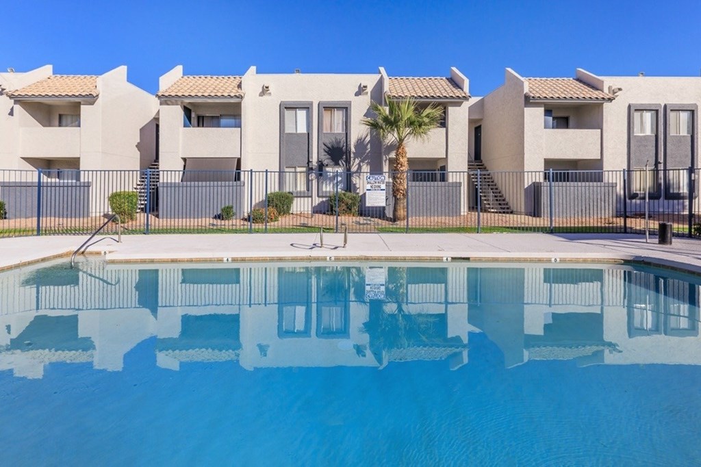 A row of houses with a pool in front.