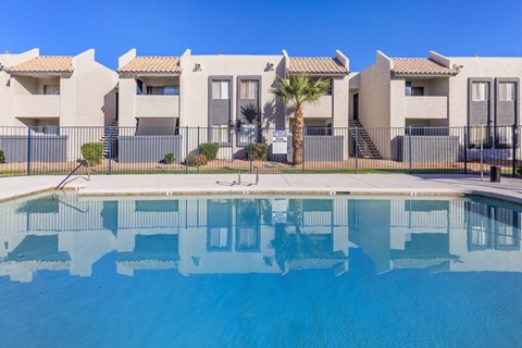 A row of houses with a pool in front.
