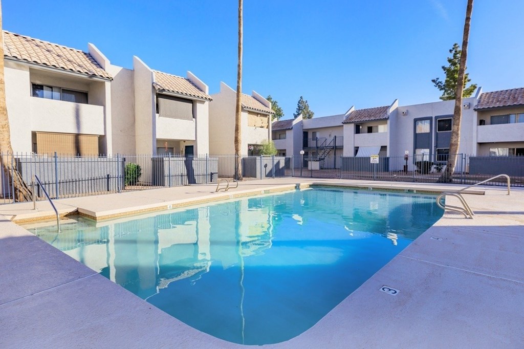 A swimming pool in front of a row of houses.