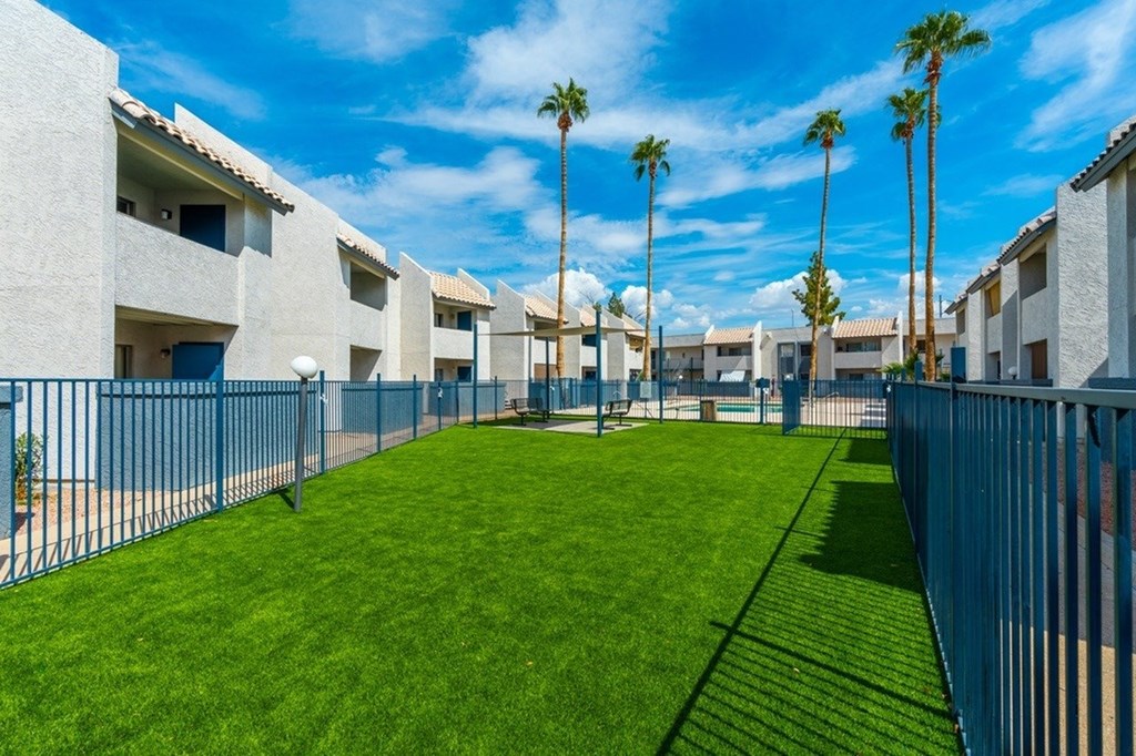 A row of houses with a green lawn in front.