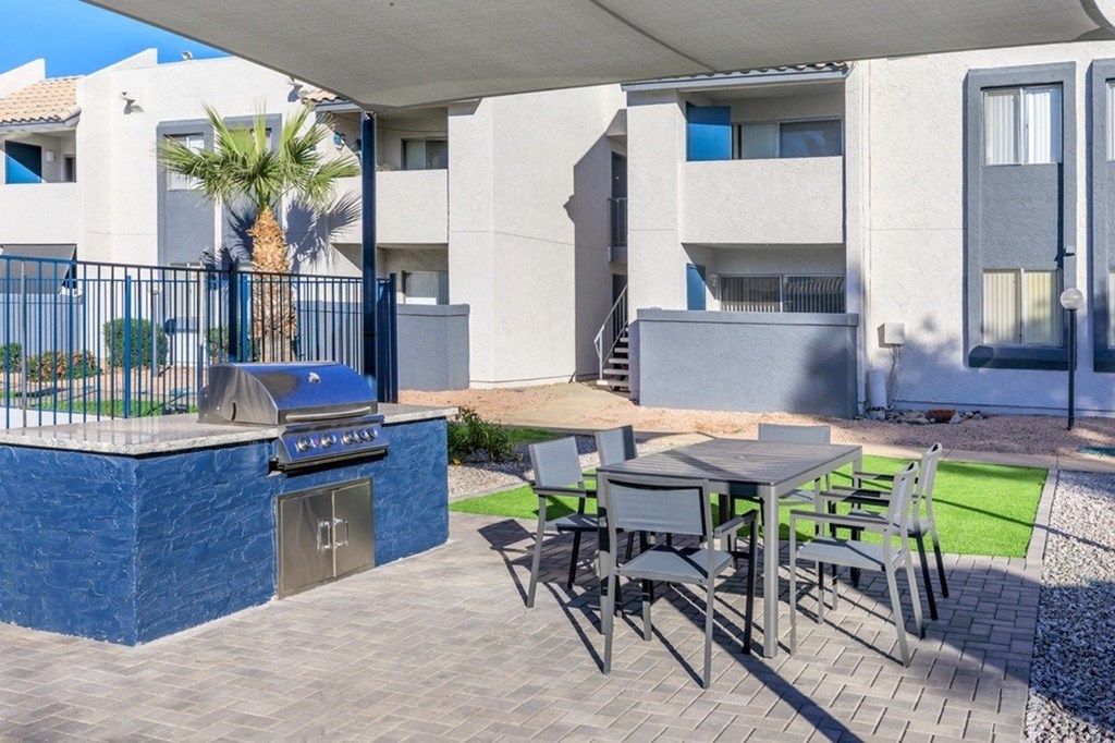 A patio with a table and chairs and a pool.